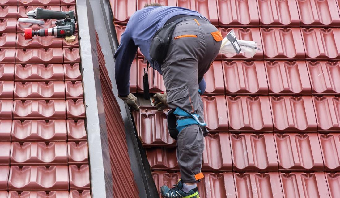 Ein Handwerker repariert ein Dach.
