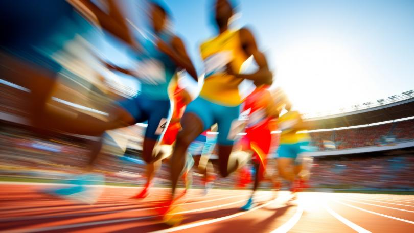 Das Bild zeigt Athleten auf der Laufbahn eines Stadions