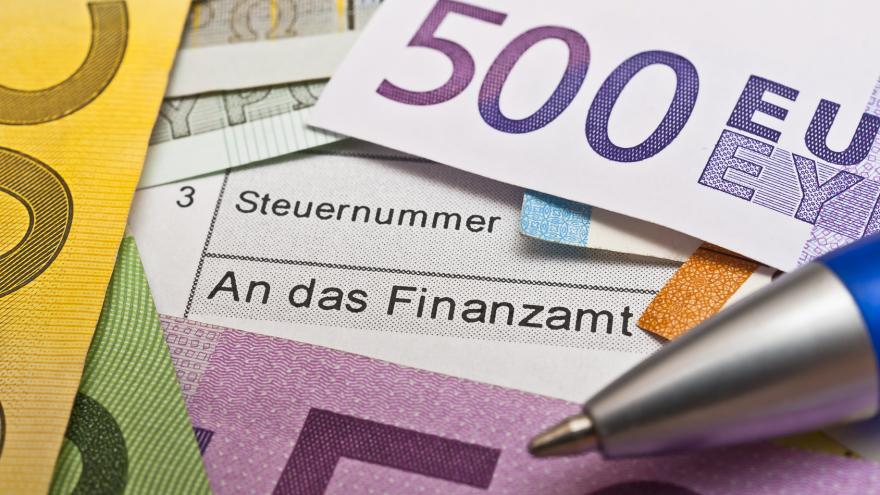 Steuerformular mit Schrift "Steuernummer" und "An das Finanzamt", auf dem Euro-Geldscheine und die Spitze eines Kugelschreibers liegen Foto: Stockfotos-MG / Fotolia.com