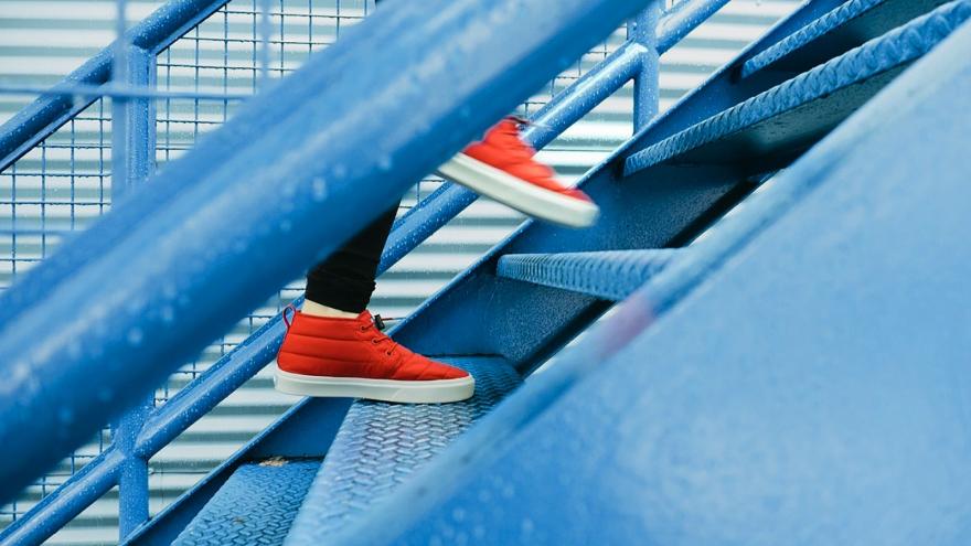 Person mit roten Schuhen läuft blaue Treppe hich