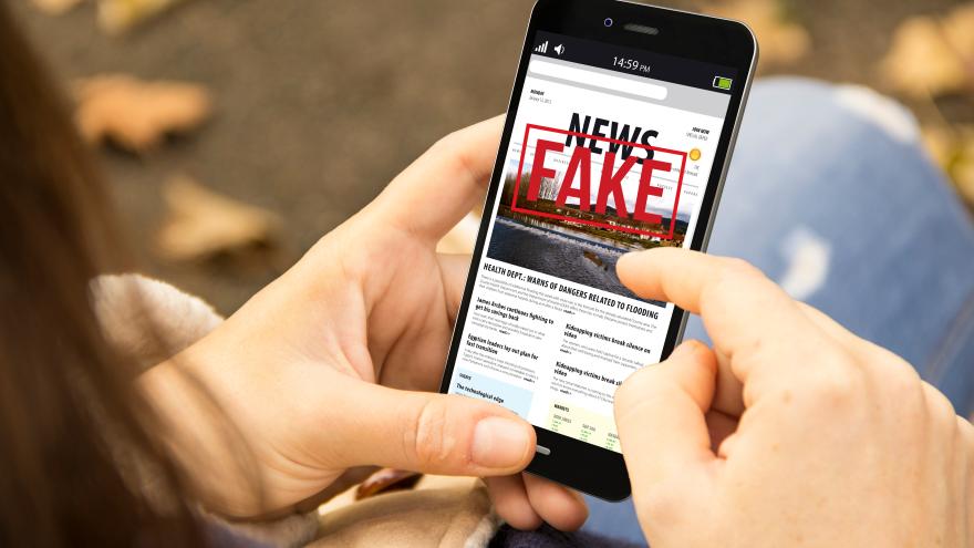 Handy mit Überschrift Fake News auf dem Display 