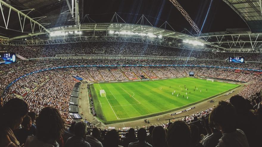 Ein Fußballstadion mit Spielern auf dem Feld und Zuschauern auf den Rängen