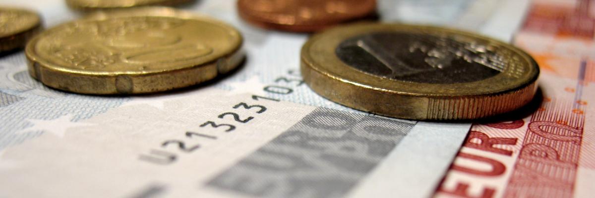 Kleine Euro-Scheine und Münzen liegen aufeinander