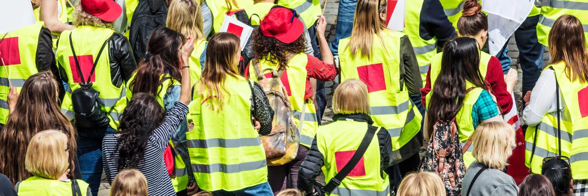 Streikende Menschen in Gewerkschaftsjacken und mit Fahnen