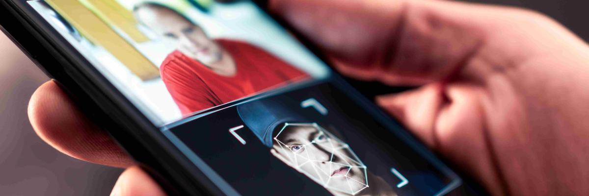  „Smartphone zeigt ein manipuliertes Porträt mit Deepfake-Technologie: Eine Person hält ein Handy, auf dessen Bildschirm ein Gesicht mithilfe künstlicher Intelligenz verändert wurde. Symbolbild für Deepfake, Gesichtstausch, Identitätsdiebstahl und KI-gestützte Bildbearbeitung.