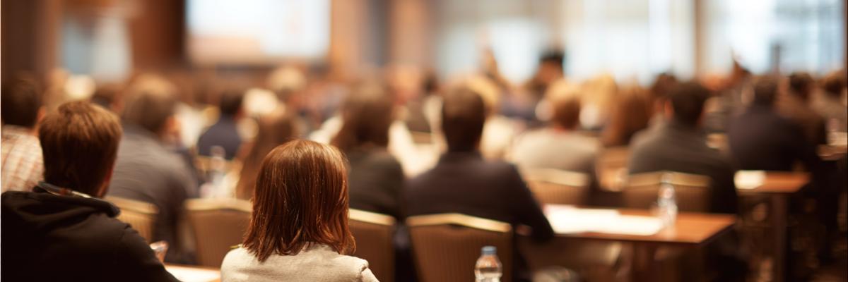 Ein voller Saal mit Publikum bei einem Vortrag