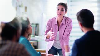 Frau erklärt anderen in einer Sitzung etwas