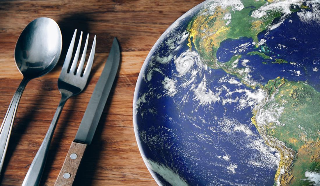 Ein Teller mit dem Planet-Bild auf dem Tisch mit Löffel, Gabel und Messer